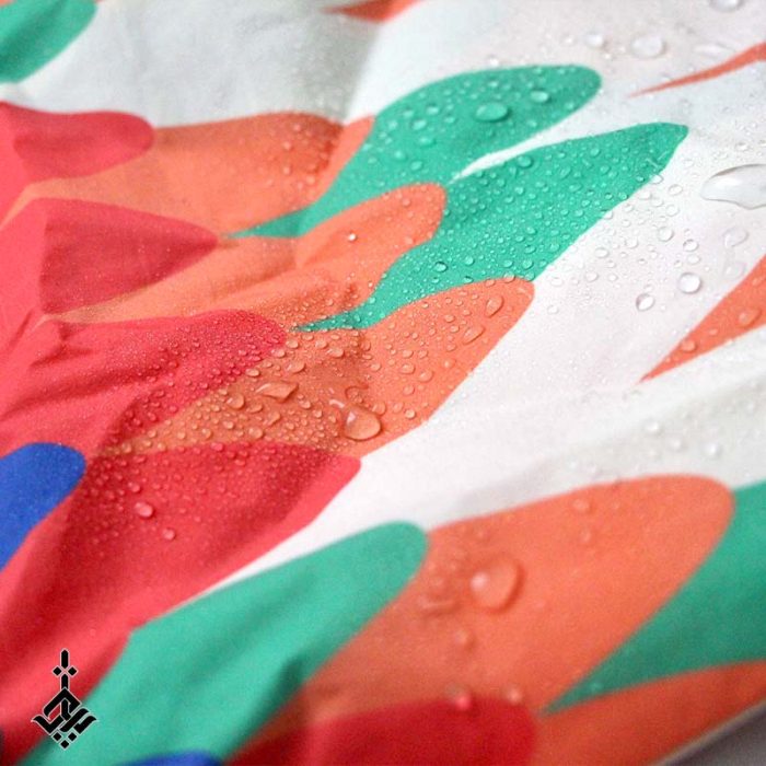 تصویر کیف پارچه ای جمع شو ضد آب رنگارنگ از نزدیک با قطره های آب روی آن